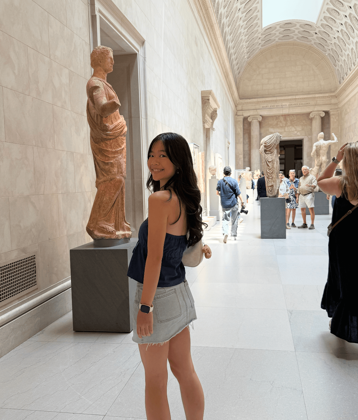 Doris in a museum gallery lined with classical sculptures